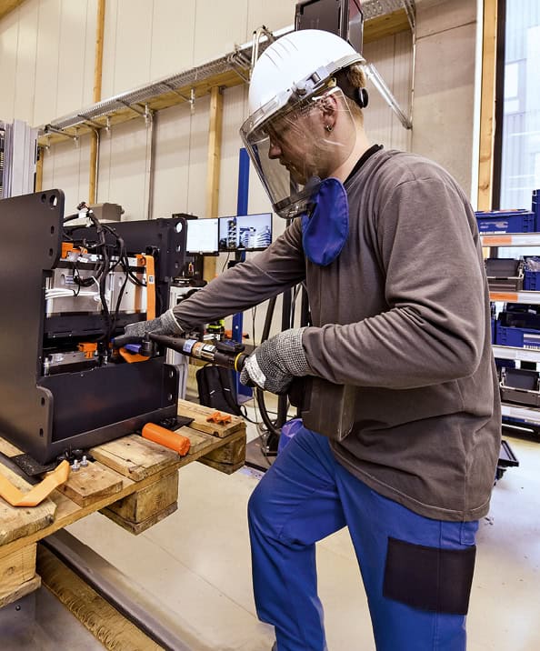 Mann bei Arbeit an industrieller Maschine in Werkstatt.