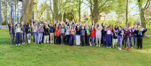 Große Gruppe von Menschen im Park bei Power-Event, fröhlich und motiviert.