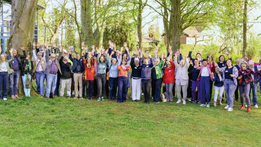 Große Gruppe von Menschen im Park bei Power-Event, fröhlich und motiviert.